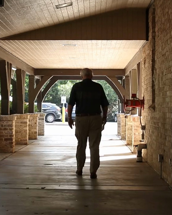 photo of a man walking away through church breezway