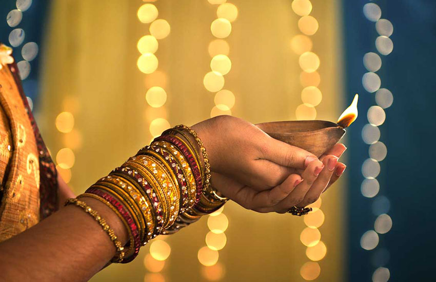 Someone holding a burning diya