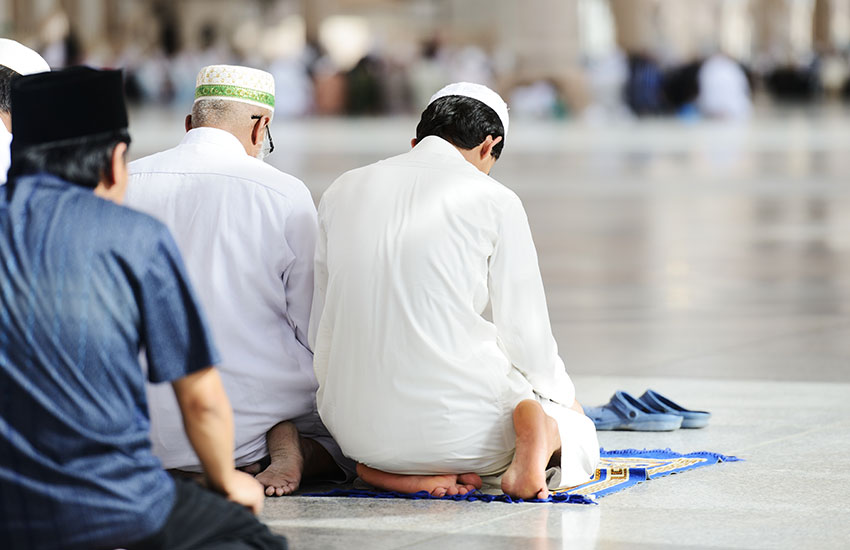 Muslims kneeling and praying in a temple
